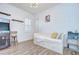 Bright bedroom featuring shuttered windows, arcade game, modern light fixture and wood-look flooring at 4122 Natural Vista Ct, New Port Richey, FL 34655