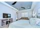 A spacious bedroom features a tray ceiling, wood floors, plantation shutters and stylish furniture at 4122 Natural Vista Ct, New Port Richey, FL 34655