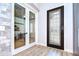 Elegant entryway featuring stylish tile flooring, a decorative front door, and glass paneled office doors at 4122 Natural Vista Ct, New Port Richey, FL 34655