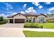 Beautiful single-story home featuring a three-car garage, paver driveway, and lush landscaping at 4122 Natural Vista Ct, New Port Richey, FL 34655