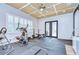 Bright home gym with exercise equipment, coffered ceiling, and shuttered windows for private workouts at 4122 Natural Vista Ct, New Port Richey, FL 34655