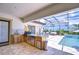 Inviting outdoor kitchen features stainless appliances, bar, and tiled flooring for perfect outdoor entertaining at 4122 Natural Vista Ct, New Port Richey, FL 34655
