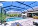 Sparkling pool with sun loungers and an outdoor kitchen under a screened lanai and blue skies at 4122 Natural Vista Ct, New Port Richey, FL 34655