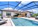 Backyard pool with screened enclosure, seating, and an outdoor kitchen, perfect for entertaining at 4122 Natural Vista Ct, New Port Richey, FL 34655