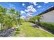Manicured side yard features lush greenery, well-placed palm trees, and a charming walking path at 4122 Natural Vista Ct, New Port Richey, FL 34655
