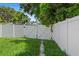 A white fence secures the grassy backyard with a walkway leading to the yard at 4242 7Th N Ave, St Petersburg, FL 33713