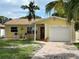 Close up of a charming yellow single-story home with a well-manicured lawn and brick driveway at 4242 7Th N Ave, St Petersburg, FL 33713