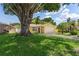 Charming yellow home with well-maintained lawn and a large shade tree in the front yard at 4242 7Th N Ave, St Petersburg, FL 33713