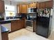 View of kitchen, featuring stainless appliances, wood cabinets and black refrigerator at 4242 7Th N Ave, St Petersburg, FL 33713