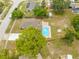 An aerial view reveals a kidney bean pool, spacious yard, patio area, and the neighborhood at 4313 Riviera Ct, Spring Hill, FL 34608