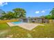 Wide backyard featuring a kidney bean-shaped pool and a brick patio area on a well-maintained lawn at 4313 Riviera Ct, Spring Hill, FL 34608