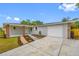 Charming home with a manicured front yard, brick columned entryway, neutral paint and attached garage at 4313 Riviera Ct, Spring Hill, FL 34608