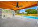 Covered patio overlooking a sparkling pool, perfect for outdoor relaxation and entertaining with ceiling fans at 4313 Riviera Ct, Spring Hill, FL 34608