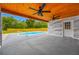 Outdoor patio area with a clear view of the pool, wooden ceiling, and private backyard space at 4313 Riviera Ct, Spring Hill, FL 34608