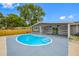 Backyard view of a private Kidney Bean pool with an adjacent covered patio featuring ceiling fans at 4313 Riviera Ct, Spring Hill, FL 34608