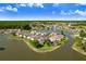 Wide aerial view of homes nestled along a serene lake in a beautiful neighborhood at 4407 Whitton Way, New Port Richey, FL 34653