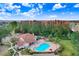 Aerial view of a community pool surrounded by buildings, lush trees and greenery under a sunny sky at 4407 Whitton Way, New Port Richey, FL 34653