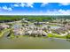 An aerial shot shows waterfront homes surrounded by lush greenery and a beautiful lake community at 4407 Whitton Way, New Port Richey, FL 34653