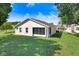 Exterior backyard view of home featuring a screened in lanai and lush green lawn at 4407 Whitton Way, New Port Richey, FL 34653