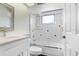 Bathroom featuring a vanity area and bathtub with glass shower door enclosure at 4407 Whitton Way, New Port Richey, FL 34653