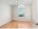 Cozy bedroom featuring a large window and light hardwood flooring at 4407 Whitton Way, New Port Richey, FL 34653