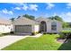 Single-story home with well-manicured lawn, trimmed shrubs and gray garage door at 4407 Whitton Way, New Port Richey, FL 34653