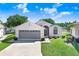 Charming single-story home with a well-maintained lawn, gray garage door, and inviting front entrance at 4407 Whitton Way, New Port Richey, FL 34653