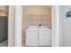 Small laundry room area includes a washer and dryer and wire shelving at 4407 Whitton Way, New Port Richey, FL 34653