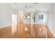 Open living room with hardwood floors, ceiling fan, and view into kitchen and laundry room at 4407 Whitton Way, New Port Richey, FL 34653