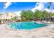 Community pool and surrounding area with chairs and umbrellas, creating a perfect spot for relaxation at 4407 Whitton Way, New Port Richey, FL 34653