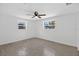 Sunlit bedroom featuring two windows, ceiling fan, and neutral tile flooring at 4535 15Th S Ave, St Petersburg, FL 33711