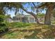Inviting view of a single-story home with a stone exterior, complemented by lush greenery and mature trees at 4535 15Th S Ave, St Petersburg, FL 33711