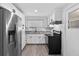 Modern kitchen showcasing white cabinetry, stainless steel refrigerator, and black appliances at 4535 15Th S Ave, St Petersburg, FL 33711