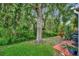 Lush green backyard featuring mature trees and a wood deck at 5502 Carrollwood Key Dr, Tampa, FL 33624
