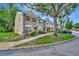 Charming townhome featuring neutral stucco and wood accents, with mature trees surrounding the property at 5502 Carrollwood Key Dr, Tampa, FL 33624