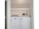 A compact laundry closet featuring a washer and dryer and wire shelving at 5502 Carrollwood Key Dr, Tampa, FL 33624
