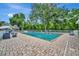 Community pool with brick paver deck, privacy fence and ample seating under a bright sky at 5502 Carrollwood Key Dr, Tampa, FL 33624