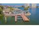 A waterfront home with a private dock, lush landscaping, and an inviting backyard pool and spa at 5950 Bikini N Way, St Pete Beach, FL 33706