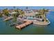 Waterfront property with dock, boat lift, pool, lush landscaping, and outdoor entertaining area at 5950 Bikini N Way, St Pete Beach, FL 33706