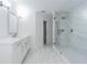 Bathroom features a glass-enclosed shower with marble-look tile and vanity at 5950 Bikini N Way, St Pete Beach, FL 33706