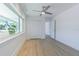 This bedroom features a ceiling fan, a closet, a window and luxury vinyl plank flooring at 5950 Bikini N Way, St Pete Beach, FL 33706