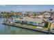 Waterfront home featuring a pristine pool, lush landscaping and fenced yard offering direct water access at 5950 Bikini N Way, St Pete Beach, FL 33706