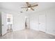 Bright bedroom with neutral walls, ceiling fan, and doorway leading to ensuite bathroom with vanity sink at 6220 Murdock Ave, Sarasota, FL 34231