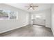 A bright bedroom with modern wood-look flooring, a ceiling fan, and abundant natural light from the windows at 6220 Murdock Ave, Sarasota, FL 34231