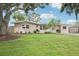 Well-manicured front yard with mature trees, complemented by a charming one-story home featuring neutral stucco at 6220 Murdock Ave, Sarasota, FL 34231