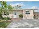 Inviting front entrance with blue accent door, complimented by lush landscaping and a brick-lined walkway at 6220 Murdock Ave, Sarasota, FL 34231