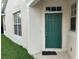 Charming front door features a vibrant green color, contrasting the neutral walls of the exterior at 6252 Olivedale Dr, Riverview, FL 33578
