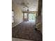 Spacious living room featuring neutral walls, high ceilings and glass sliding doors to let natural light pour in at 6252 Olivedale Dr, Riverview, FL 33578