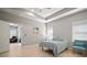 Bright bedroom featuring a tray ceiling, complemented by an adjacent sitting area at 6408 Seasound Dr, Apollo Beach, FL 33572
