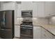 Well-equipped kitchen showcases stainless steel appliances and white cabinetry with complementing backsplash and countertops at 6408 Seasound Dr, Apollo Beach, FL 33572